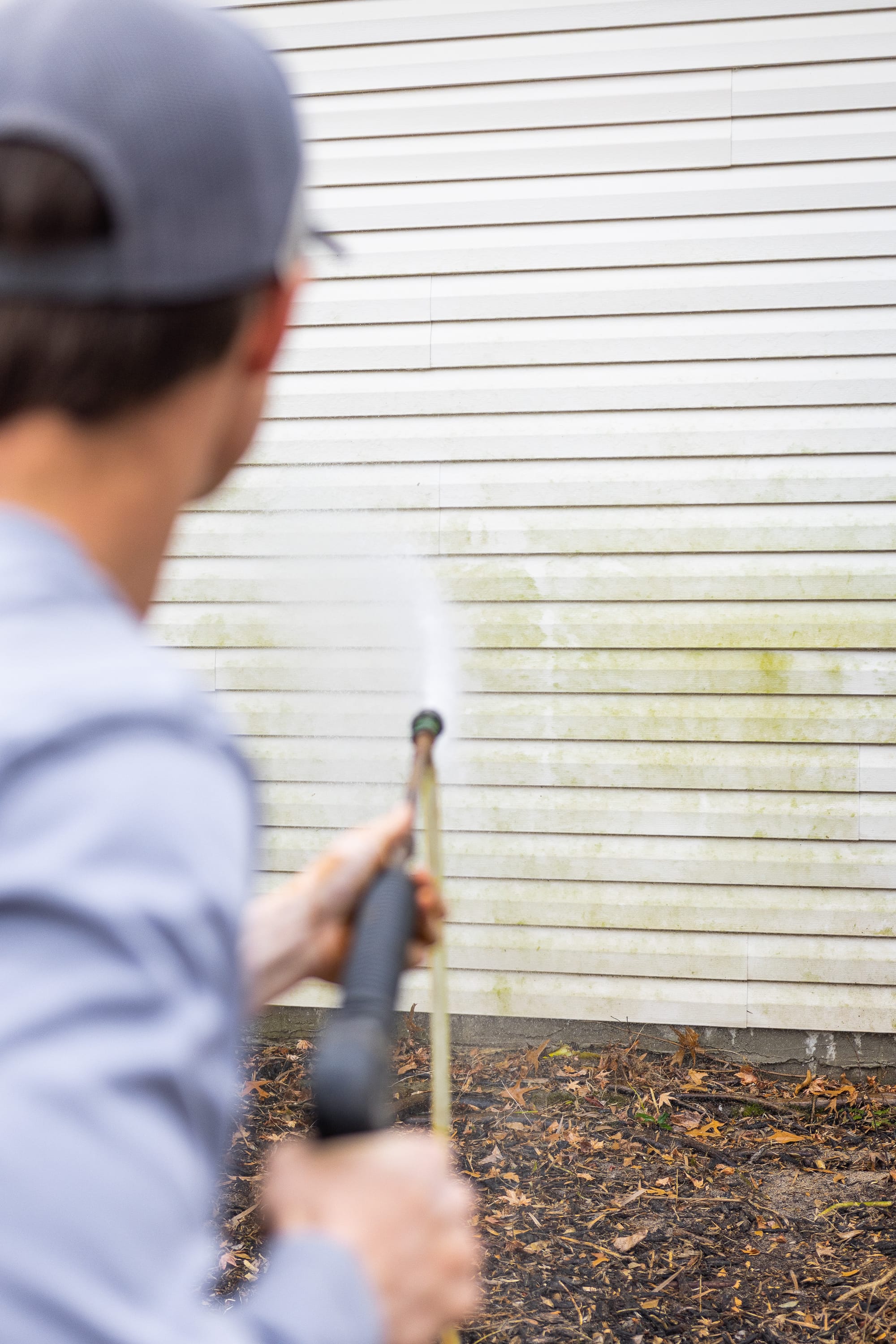 Close up of crew member using soft wash pressure washer